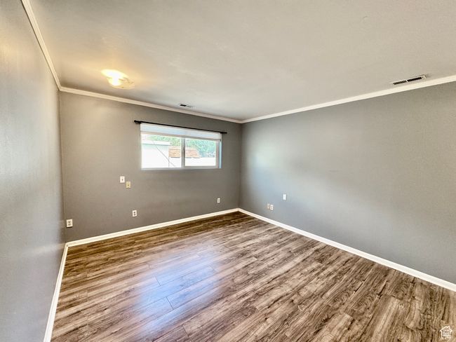 Empty room featuring visible vents, baseboards, ornamental molding, and wood finished floors | Image 28