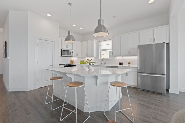This meticulously maintained contemporary island kitchen serves as the heart of the home with inviting warp around bar seating that everyone will want to gather around. | Image 13