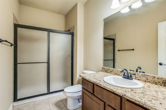 Full bathroom featuring toilet, a stall shower, vanity, and tile patterned flooring | Image 10