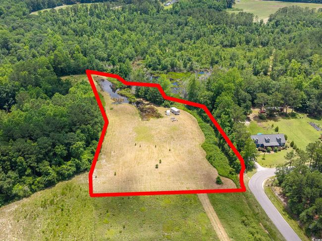 Aerial view of property and surrounding area featuring a heavily wooded area and property boundaries highlighted | Image 9