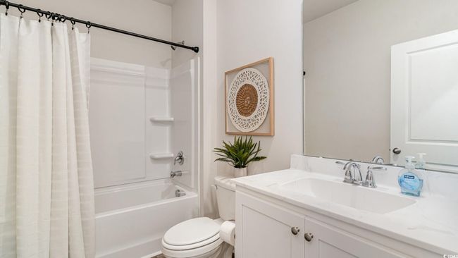 Bathroom featuring shower / bath combination with curtain, toilet, and vanity | Image 22