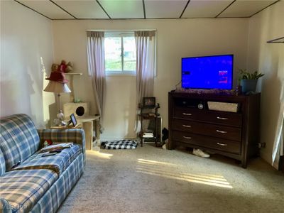 Carpeted living room with a drop ceiling | Image 2