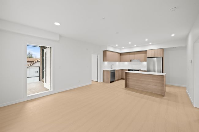 Kitchen featuring appliances with stainless steel finishes, modern cabinets, light countertops, a kitchen island, and light wood-style flooring | Image 9