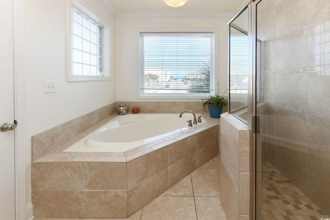 Full bath featuring a bath, a stall shower, tile patterned flooring, and crown molding | Image 12