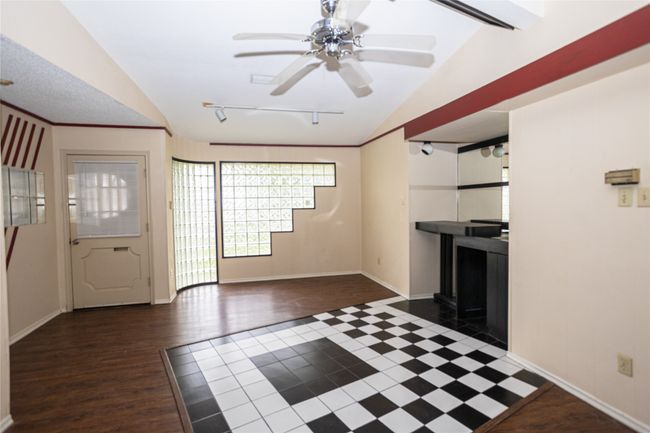 Unfurnished living room with vaulted ceiling, ceiling fan, rail lighting, and wood finished​​‌​​​​‌​​‌‌​‌‌​​​‌‌​​‌‌​‌​​​​​‌ floors | Image 5