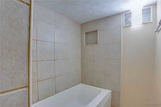 2nd unit Bathroom featuring tile walls, separate shower and tub, and a textured ceiling | Image 35