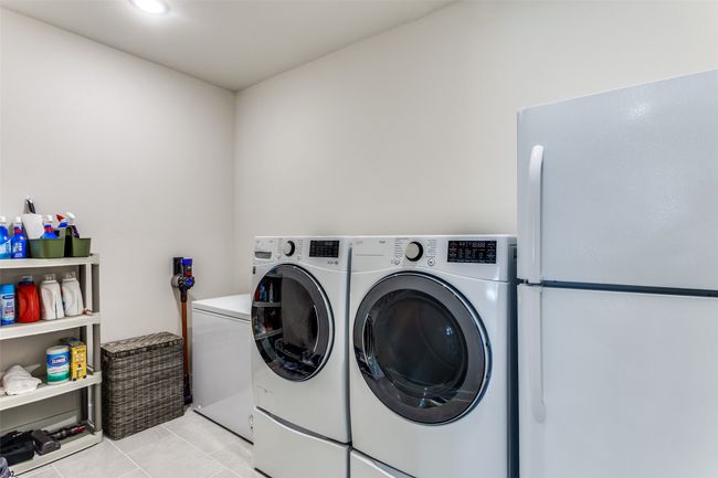 Laundry room with independent washer and dryer and light tile patterned flooring | Image 32