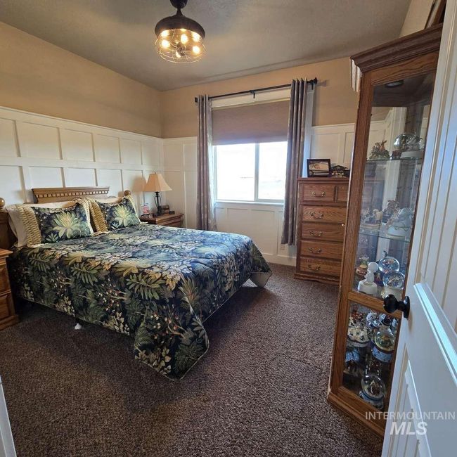 Bedroom featuring carpet flooring, a decorative wall, and wainscoting | Image 13