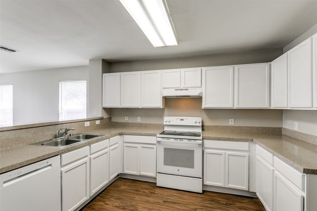 Kitchen featuring white cabinetry, white appliances, dark hardwood / wood-style floors, and sink | Image 14