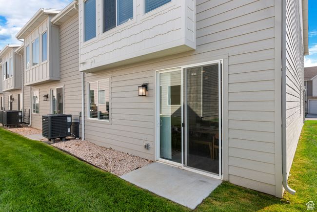 Rear view of house with a lawn and central AC | Image 28