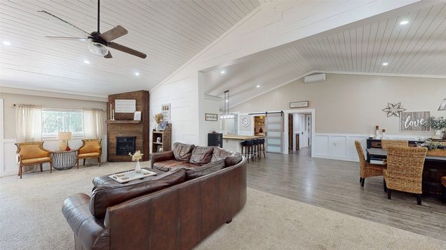 Dining area featuring lofted ceiling, hardwood / wood-style floors, wood walls, and built in shelves | Image 8