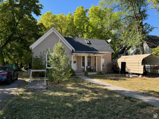 Bungalow with brick siding, a shingled roof, a front lawn, and covered porch | Image 36