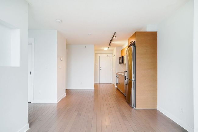 Interior space with track lighting, baseboards, and light wood-style flooring | Image 6