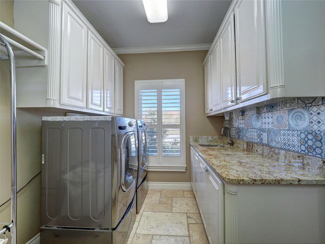 Laundry with decorative tile and utility sink | Image 39