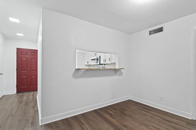 View of dining area and entry way with brand new flooring and kitchen pass through. | Image 6