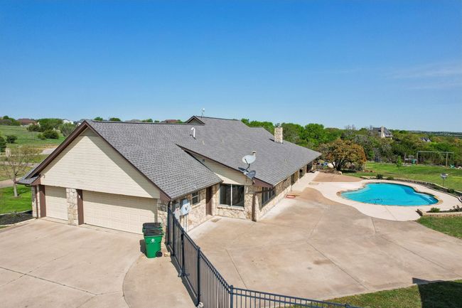 View of swimming pool featuring fence, a fenced in pool, a grill, a yard, and a patio area | Image 32