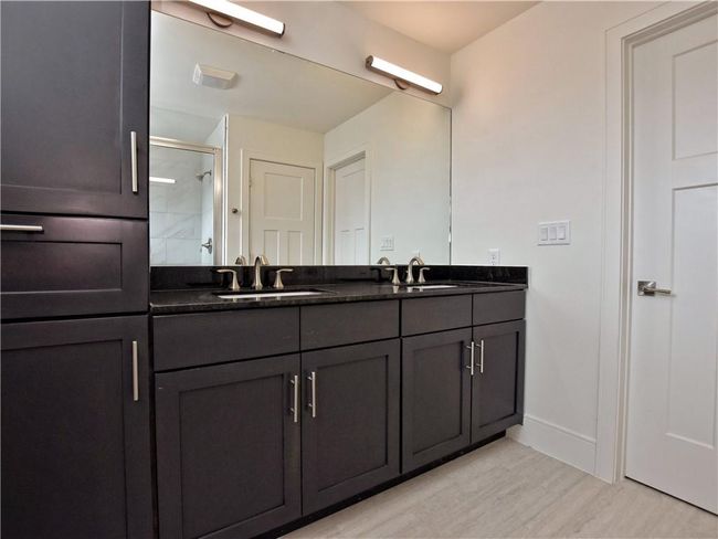 Bathroom with double vanity, an enclosed shower, and wood finished floors | Image 13