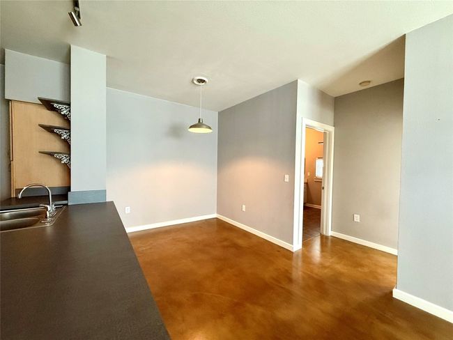 Unfurnished dining area with a sink, finished concrete floors, and baseboards | Image 17