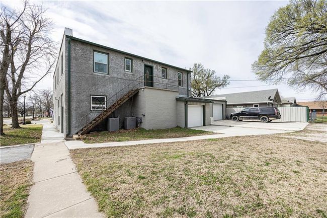 View of front of property with an attached garage, central AC, stucco siding, stairs, and concrete driveway | Image 62