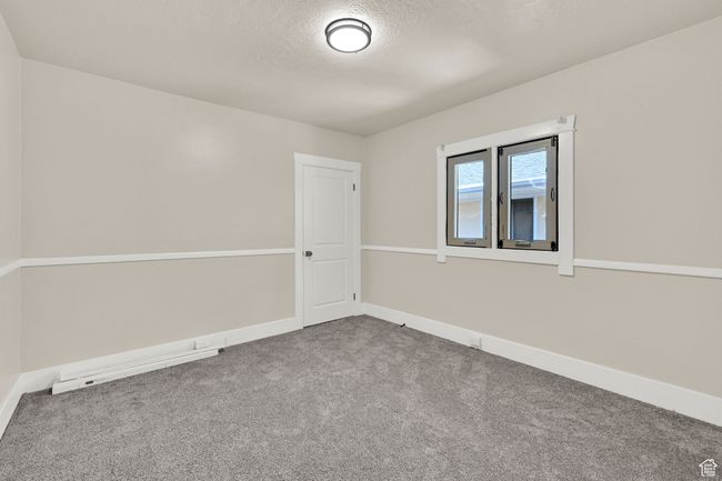 Empty room with carpet floors, a textured ceiling, and baseboards | Image 14