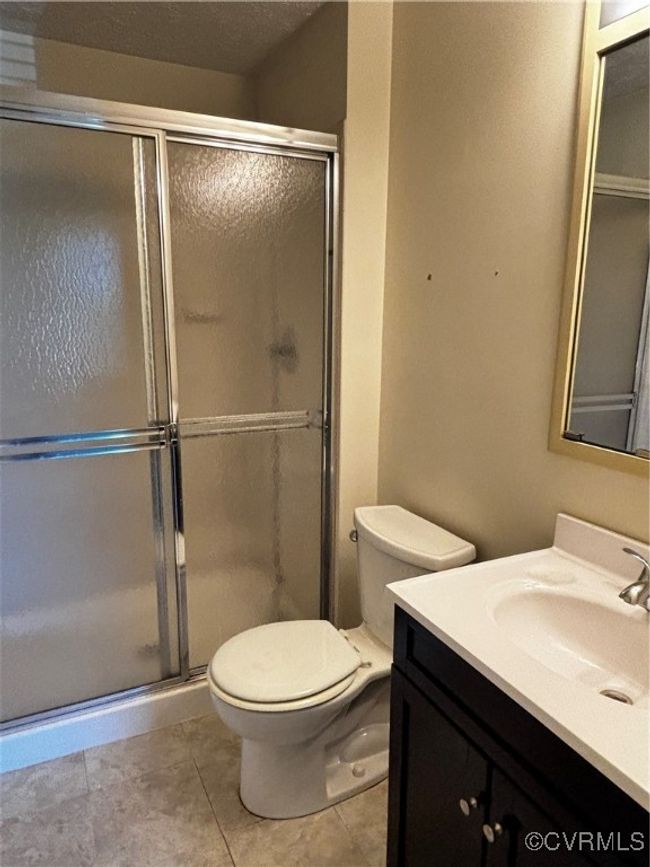 Full bath with vanity, a stall shower, and tile patterned floors | Image 14
