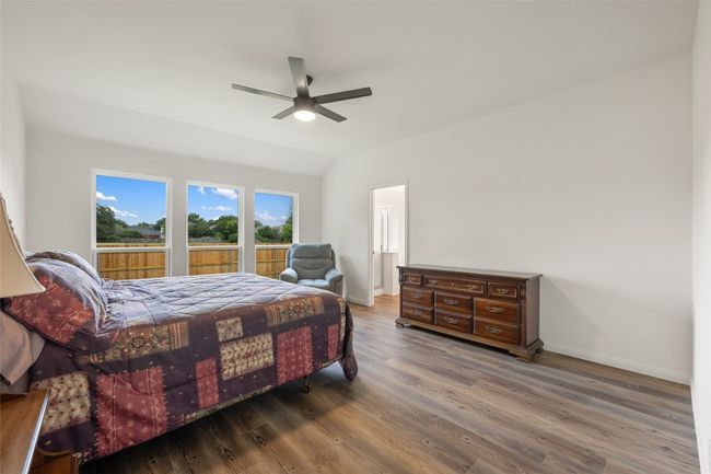 Bedroom featuring wood finished floors, a ceiling fan, and lofted ceiling | Image 24