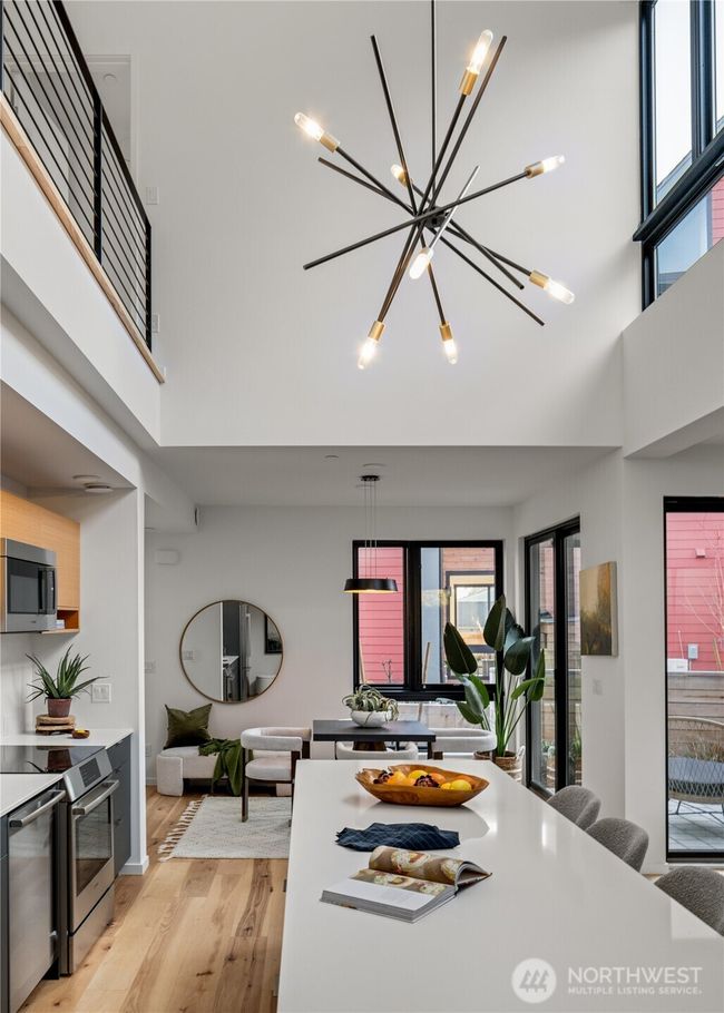 The kitchen boasts impressive double-height ceilings and features a generous island, creating a stunning focal point and providing ample space for culinary activities. | Image 5