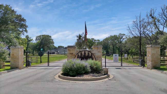 View of asphalt road featuring a gate, a gated entry, and curbs | Image 13