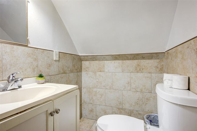Half bath with tile walls, vanity, and vaulted ceiling | Image 13