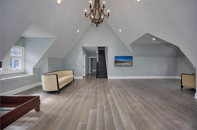 Additional living space featuring lofted ceiling, wood finished floors, a chandelier, and baseboards | Image 21