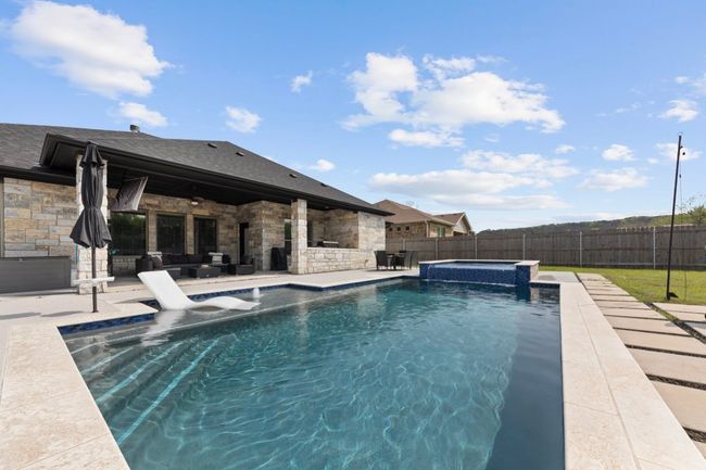 View of pool with a fenced backyard, a pool with connected hot tub, and a patio | Image 35