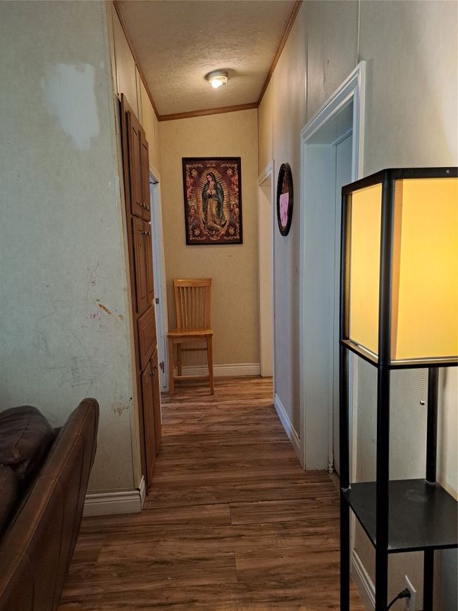 Hallway with dark wood-style flooring, a textured ceiling, and crown molding | Image 13