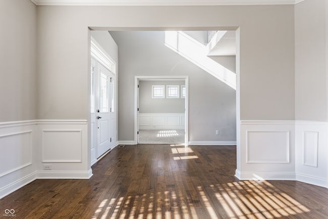 entryway featuring wood-type flooring, a wainscoted wall, and a decorative wall | Image 8