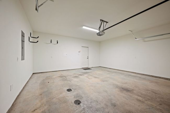 Garage featuring electric panel and a garage door opener | Image 36