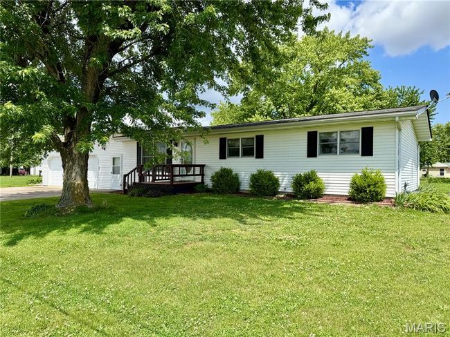 Single story home featuring a front lawn, a garage, concrete driveway, and a deck | Image 10