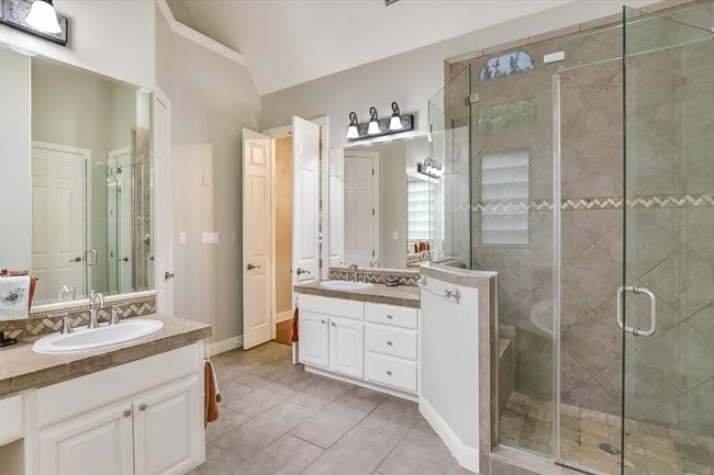 Full bathroom with two separate vanities, an oversized shower, tile patterned floors, and lofted ceiling, His/hers separate walk-in closets. | Image 15