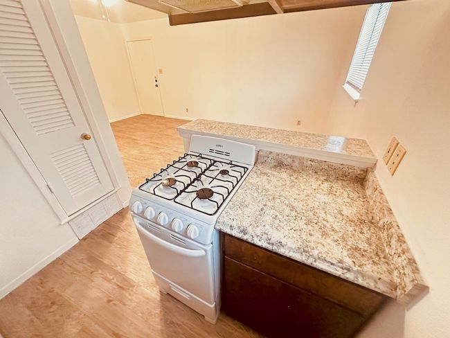 Kitchen with gas range gas stove, light wood-style flooring, and dark brown cabinets | Image 5
