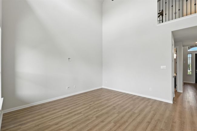 Spare room with wood finished floors and a high ceiling | Image 11
