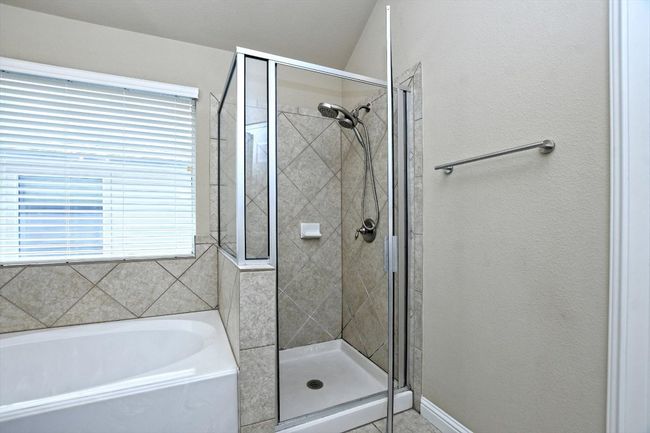Bathroom featuring a shower stall and a garden tub | Image 21