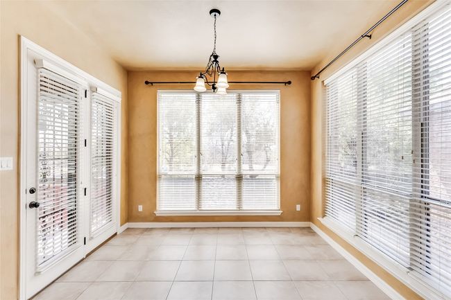 Unfurnished dining area with plenty of natural light, baseboards, and a chandelier | Image 17