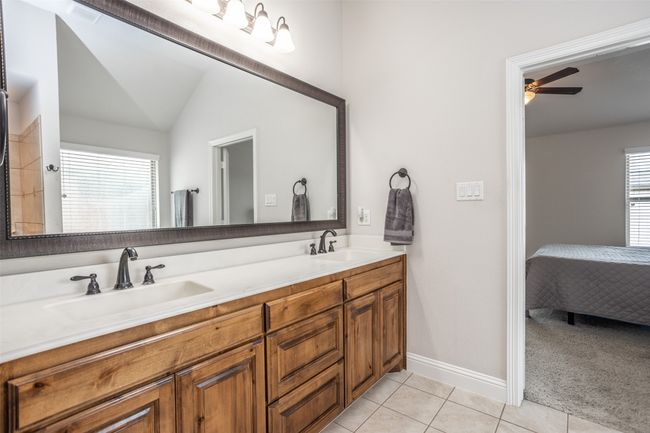 Ensuite bathroom with tile patterned flooring, double vanity, a ceiling fan, and lofted ceiling | Image 28
