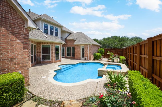 View of swimming pool with a fenced backyard, a patio area, and a pool with connected hot tub | Image 31