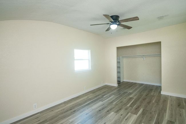 Unfurnished bedroom featuring wood finished floors, a closet, and ceiling fan | Image 14