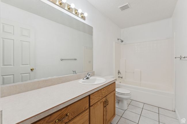 Full bath with vanity, tile patterned floors, and shower / bathtub combination | Image 11