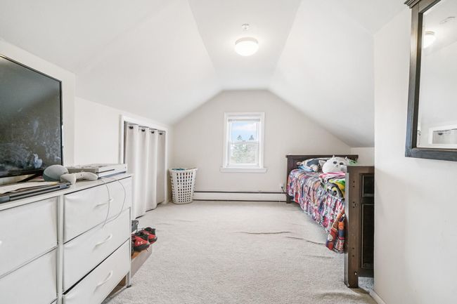 Bedroom featuring baseboard heating, vaulted ceiling, and light colored carpet | Image 20
