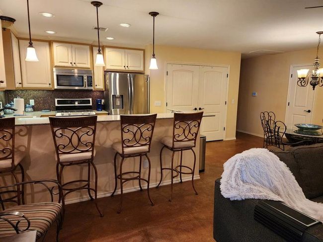 Kitchen featuring stainless steel appliances, tasteful backsplash, a breakfast bar area, recessed lighting, and light countertops | Image 16