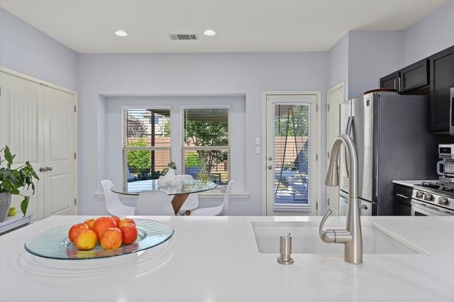 Kitchen featuring recessed lighting, light countertops, visible vents, a sink, and freestanding refrigerator | Image 16