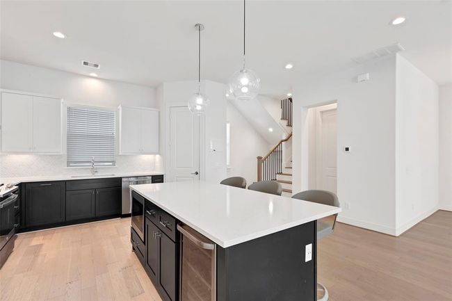 The kitchen island features a temperature controlled wine cabinet and plenty of drawers for ample storage. | Image 12