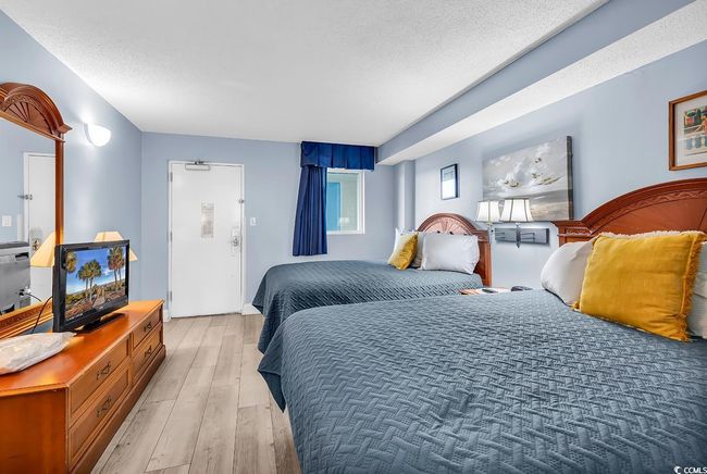 Bedroom featuring light wood-style flooring and a textured ceiling | Image 8