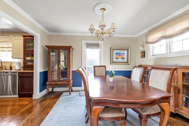Dining area featuring baseboards, dark wood-style floors, ornamental molding, and an inviting chandelier | Image 4
